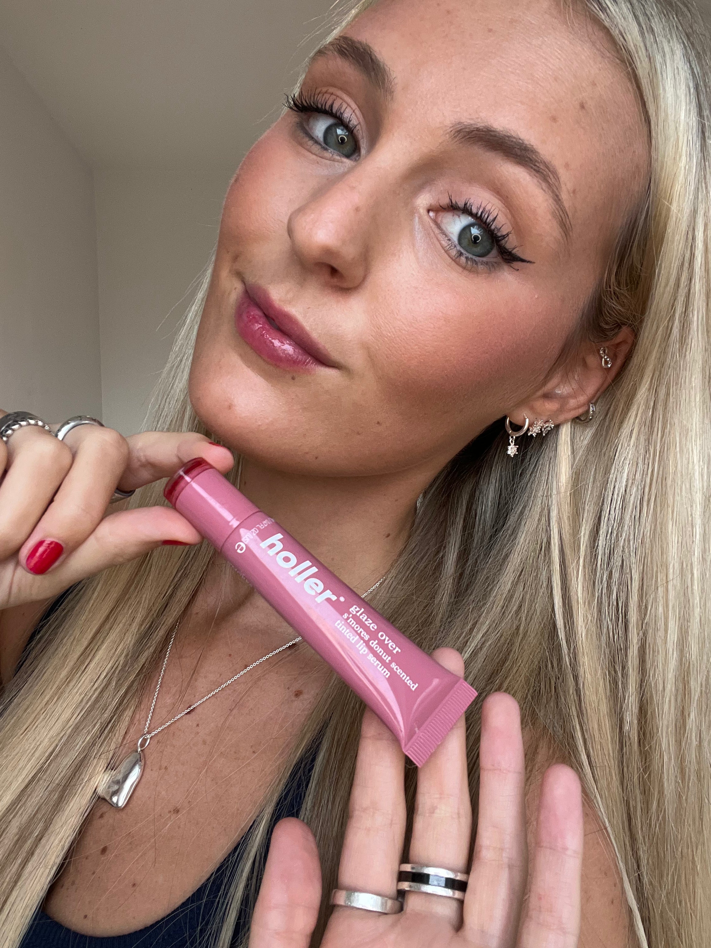 Woman holding a tube of product with 'holler' on it. 