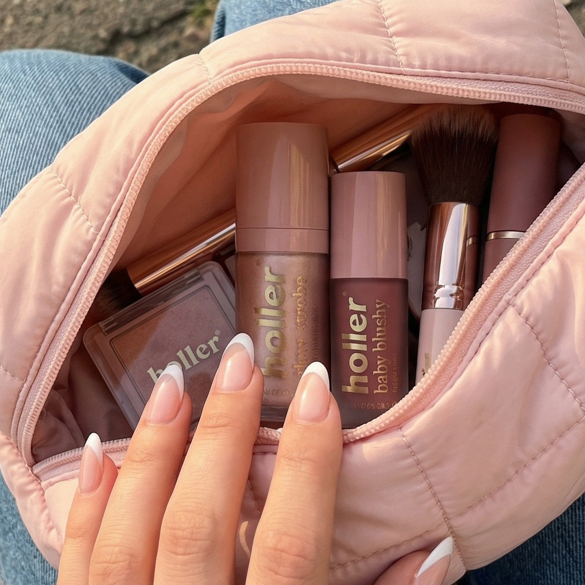 Makeup bag with Holler products held by a hand